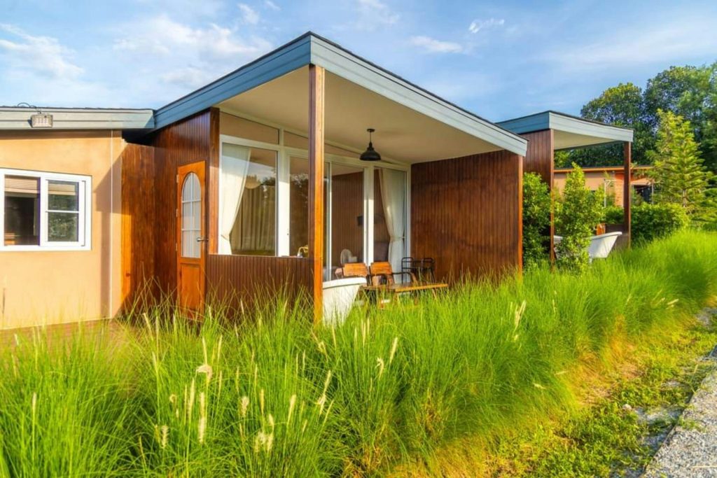 Ein kleines Haus, das auf einem saftig grünen Feld thront.